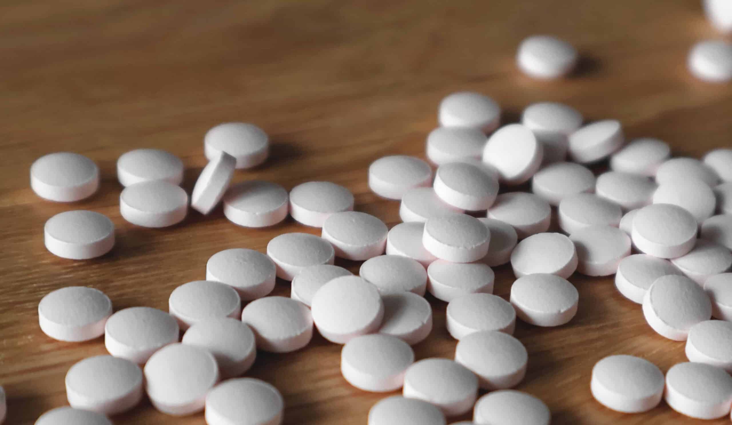 Weiße Tabletten auf Holzuntergrund